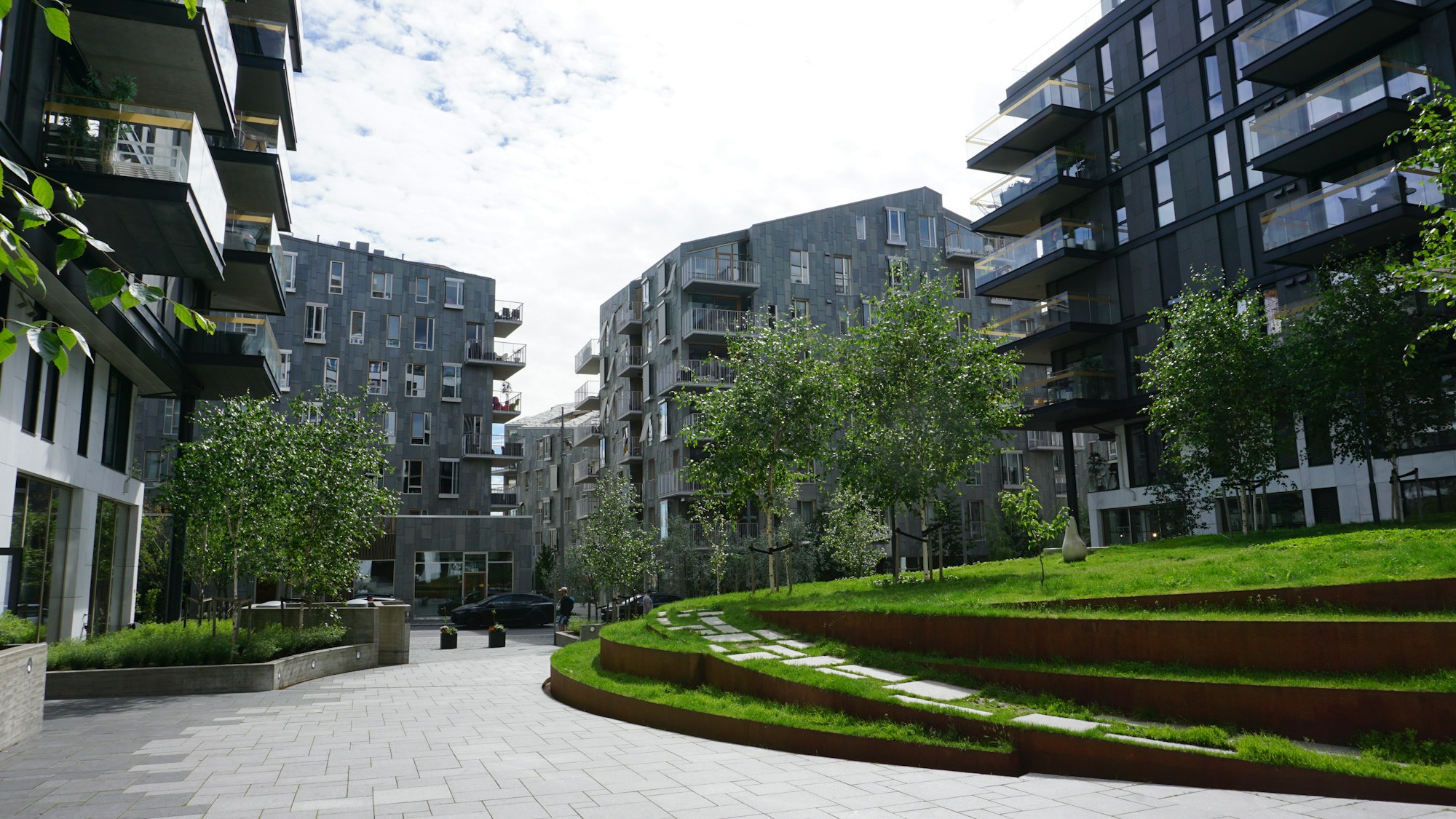 Moderne borettslag med grønne uteområder i solskinn
